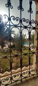 an iron gate with a view of a garden at Sbai Palace in Mhamid