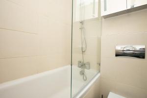 a bathroom with a shower and a bath tub at 1 Bedroom Baker Street Central Apartment in London