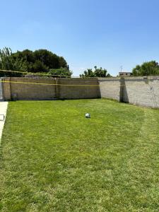 un campo de hierba con una bola en el medio en Villa Perilli - Luxury Stay con piscina privata, en Diso