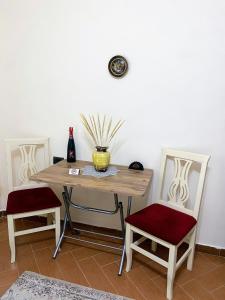 een tafel met twee stoelen en een vaas erop bij Aron’s House in Krujë