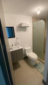 een witte badkamer met een toilet en een wastafel bij Apartamento hermoso Playa Blanca in Punta Leona