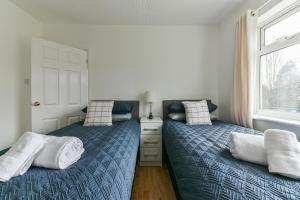 um quarto com 2 camas e uma janela em Fabulous 3 Bedroom House Near Black Country Museum Contractors & families em Tipton