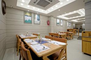 ein Esszimmer mit Holztischen und Stühlen in der Unterkunft Hotel Lake Point in Ahmedabad