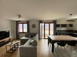 a living room with a couch and a table at Appartement au pied des cols in Saint-Jean-de-Maurienne
