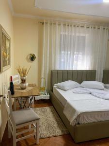 1 dormitorio con 1 cama y 1 mesa con silla en Aron’s House, en Krujë