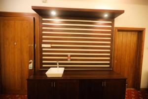 a bathroom with a sink and a wooden wall at Ramadia Ran Mal Holiday Resort in Moratuwa