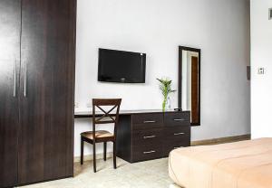 a bedroom with a desk with a television and a chair at Hotel Kariña Maturín in Maturín