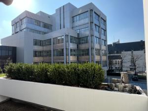 un grand bâtiment blanc avec des buissons devant lui dans l'établissement URBAN Studio Apartment mit Designerbad Sehr zentrale Lage 5 Minuten zu Fuß in die Innenstadt, à Oldenbourg