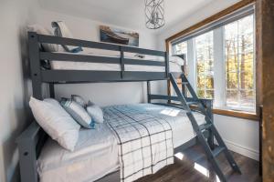 a bunk bed in a room with a window at LoveNestChalet - Hot tub & Fireplace - Warm, cozy & relaxing in Grenville-sur-la-Rouge