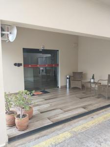 an empty room with potted plants on a wooden floor at Leme Plaza Hotel in Leme