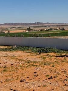 une clôture au milieu d'un champ de terre dans l'établissement مزرعة ود, à Al Qā‘id