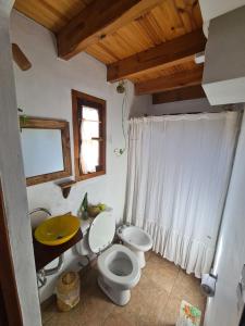 a bathroom with a toilet and a sink and a window at Casita Alegre in Cafayate