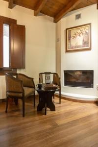 sala de estar con mesa, sillas y chimenea en Guesthouse Lousios, en Dhimitsana