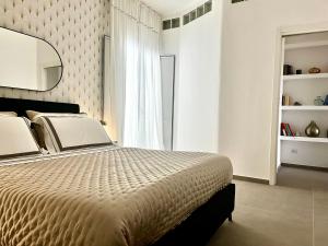 1 dormitorio con 1 cama grande y espejo en Via Dante Luxury Home, en Bari