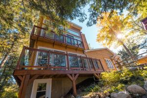 a large wooden house with a balcony at LoveNestChalet - Hot tub & Fireplace - Warm, cozy & relaxing in Grenville-sur-la-Rouge