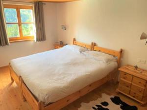 a bedroom with a wooden bed and a wooden dresser at Alleinstehendes Traumhaus in Poschiavo