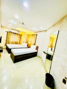 a hotel room with two beds and a mirror at Hotel Diamond inn @Esplanade in Kolkata