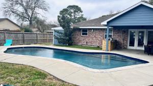 a swimming pool in front of a house at Pool/ Outdoor kitchen/Pool table in Houston