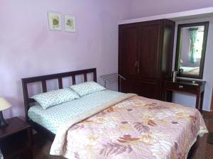 1 dormitorio con cama, tocador y espejo en Benirosa Homestay Apartments 2, en Velcao