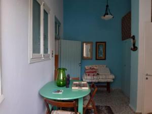 a blue room with a table and a bed at For Your Vacations Only in Galatas