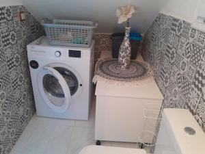 a laundry room with a washing machine and a sink at For Your Vacations Only in Galatas