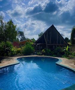 uma grande piscina azul em frente a uma casa em Cottage in Arusha-Wanderful Escape em Arusha