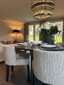 a dining room table with chairs and a vase of flowers at Appartement ALLURE 4 Zimmer Gartenwohnung in Eschen