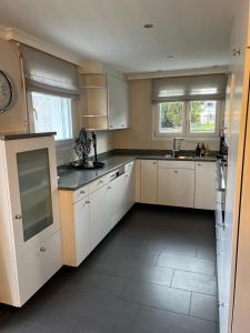 a large kitchen with white cabinets and appliances at Appartement ALLURE 4 Zimmer Gartenwohnung in Eschen