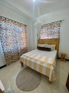a bedroom with a bed and a large window at Hideaway House in Mwanza