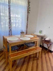 y baño con mesa de madera y lavamanos. en Hideaway House, en Mwanza