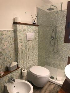 een badkamer met een toilet, een douche en een wastafel bij Brezza marina in Santa Maria Navarrese