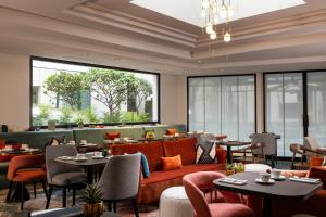 a restaurant with couches and tables and chairs at Hôtel Etoile Maillot in Paris