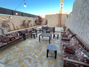 a patio with couches and tables and a wall at شاليهات حائط طيني in Riyadh