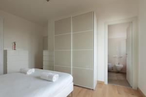 Habitación blanca con cama y baño. en Lo Spole Apartment by BarbarHouse, en Milán