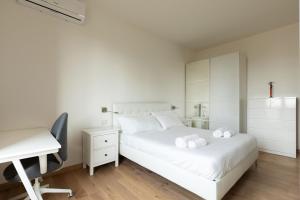 Habitación blanca con escritorio blanco y cama en Lo Spole Apartment by BarbarHouse, en Milán