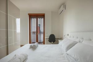 米蘭的住宿－Lo Spole Apartment by BarbarHouse，白色卧室配有白色床和椅子