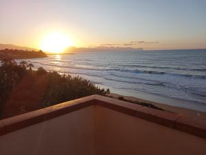 d'un balcon offrant une vue sur l'océan au coucher du soleil. dans l'établissement la finestra sul mare piano 2, à Trappeto