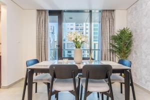 comedor con mesa, sillas y ventana en 3 Bedroom Luxurious Lake View Apartment en Dubái