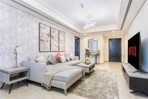 a living room with a couch and a tv at 3 Bedroom Luxurious Lake View Apartment in Dubai