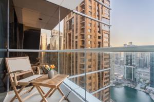 balcón con mesa y vistas a la ciudad en 3 Bedroom Luxurious Lake View Apartment en Dubái