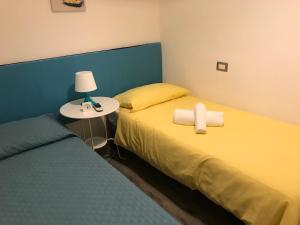 een slaapkamer met 2 bedden en een tafel met een lamp bij Brezza marina in Santa Maria Navarrese