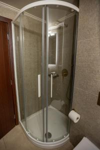 a shower with a glass door in a bathroom at Guesthouse Lousios in Dimitsana