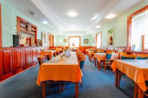 a dining room with orange tables and chairs at Penzión UNA in Liptovský Ján