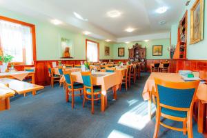 a dining room filled with tables and chairs at Penzión UNA in Liptovský Ján