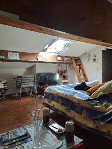 1 dormitorio con 1 cama y 1 mesa con copas de vino en ICI et MAINTENANT, en Solliès-Toucas
