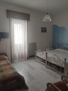 a bedroom with a bed and a window at B&B Il Cedro in Salve