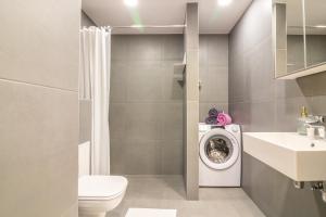 a bathroom with a toilet and a washing machine at Riia 22 Kesklinna Apartment in Tartu +9 photos