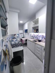 a kitchen with white cabinets and a stove in it at Renovated apartment close to the beach - Copacabana in Rio de Janeiro