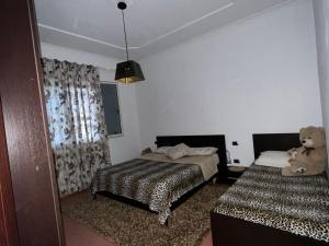 a bedroom with two beds and a teddy bear sitting on the bed at Sunny villa Borakaj Vlora in Vlorë
