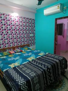 a bedroom with a bed with a colorful wall at JHARANA GUEST HOUSE in Puri